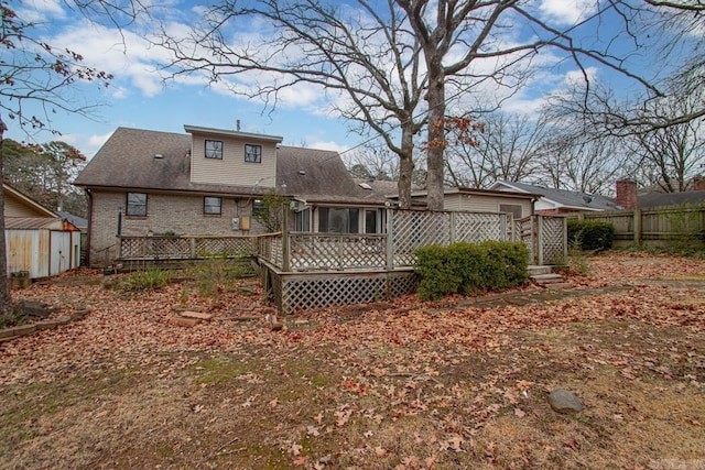 rear view of house featuring a shed and a wooden deck