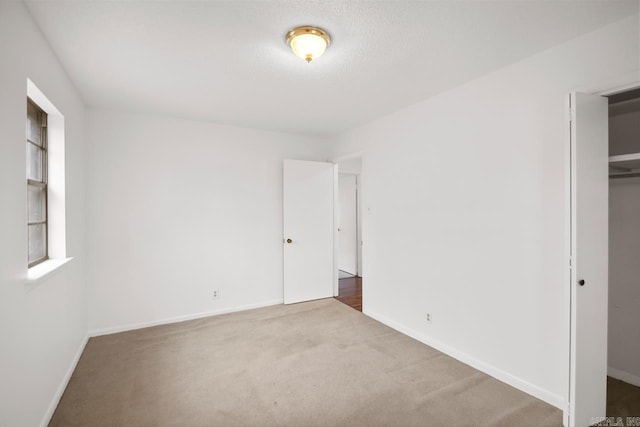 unfurnished bedroom featuring carpet flooring, a closet, and a textured ceiling