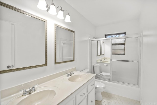 full bathroom featuring tile patterned floors, toilet, combined bath / shower with glass door, and vanity