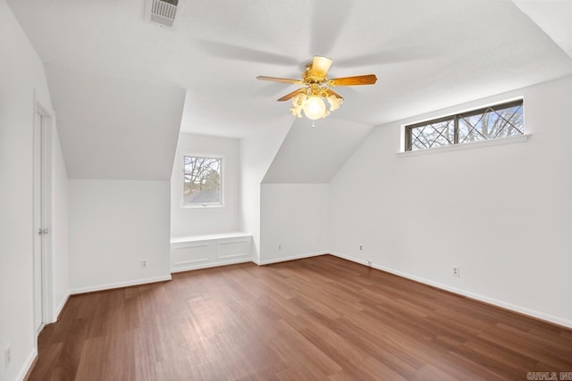 additional living space with hardwood / wood-style floors, plenty of natural light, ceiling fan, and lofted ceiling