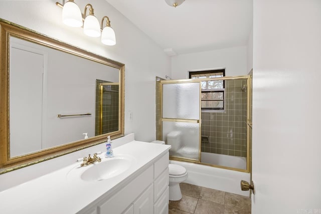 full bathroom with tile patterned floors, vanity, toilet, and bath / shower combo with glass door