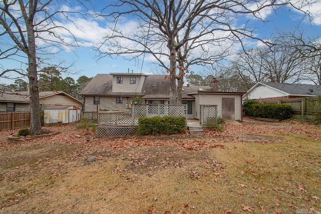 rear view of property with a yard, a shed, and a deck