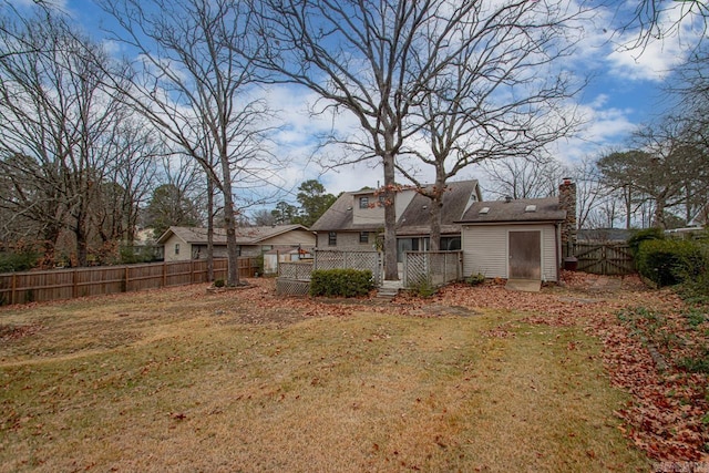 back of house with a wooden deck and a yard