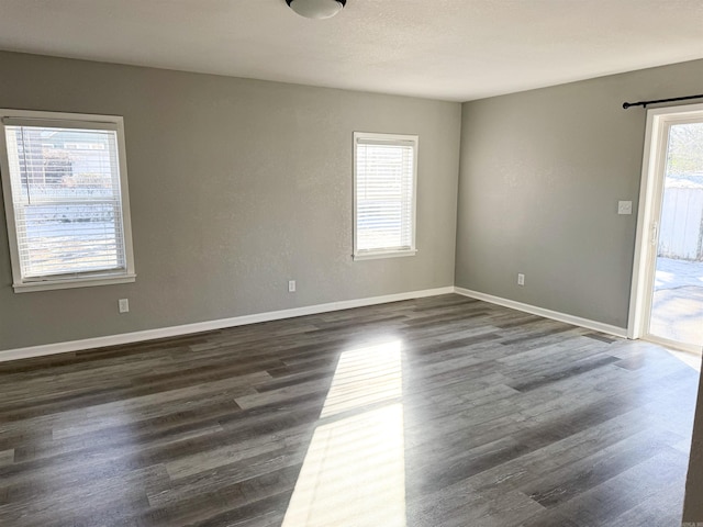 unfurnished room featuring dark hardwood / wood-style floors and a wealth of natural light