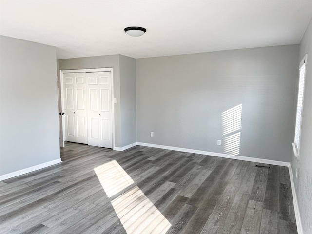 spare room with dark wood-type flooring