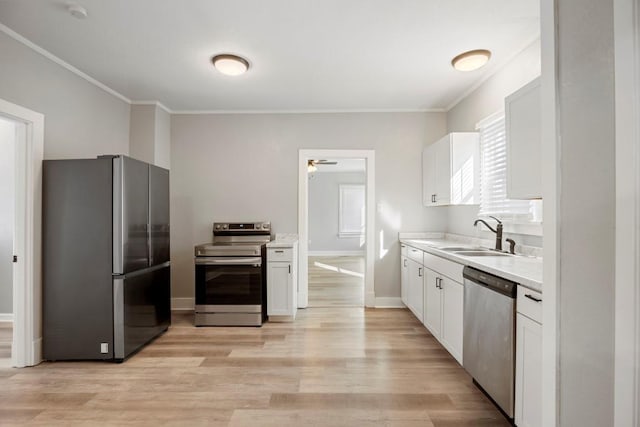 kitchen with sink, white cabinetry, light wood-type flooring, ornamental molding, and stainless steel appliances