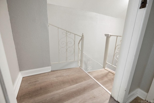 staircase with hardwood / wood-style floors