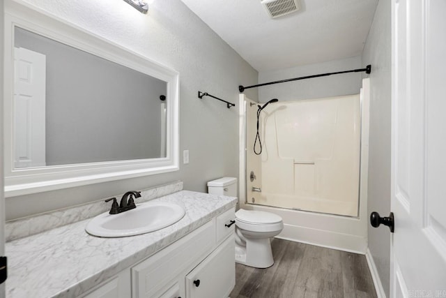 full bathroom with shower / bathing tub combination, vanity, wood-type flooring, and toilet