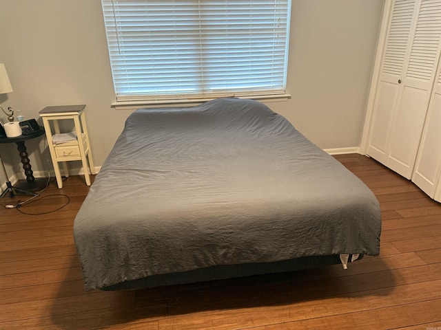 bedroom with a closet and dark wood-type flooring