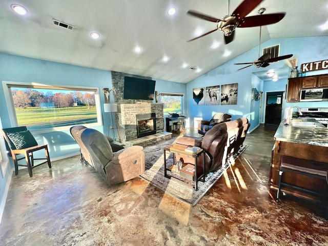 living room featuring a fireplace, ceiling fan, lofted ceiling, and sink