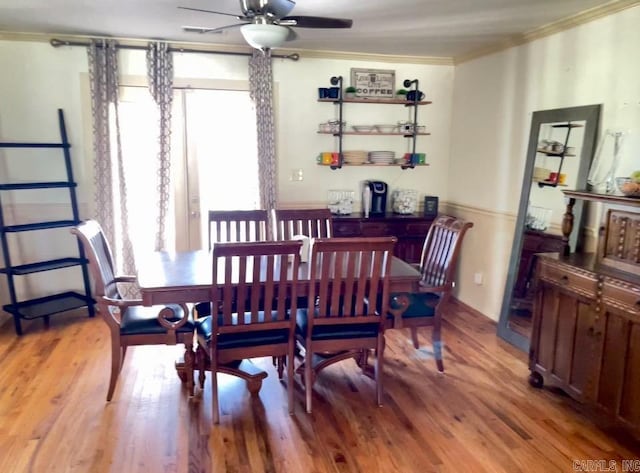 dining area with ceiling fan, ornamental molding, and light wood-type flooring