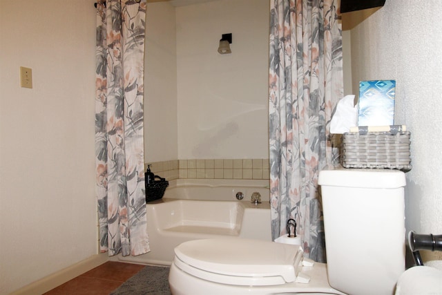 bathroom with tile patterned floors, a washtub, and toilet