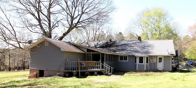 rear view of property with a wooden deck and a yard