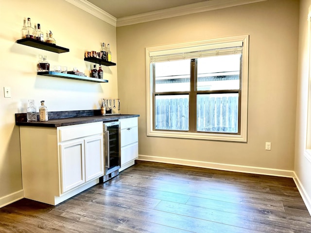 bar featuring wine cooler, white cabinets, dark wood-type flooring, and ornamental molding