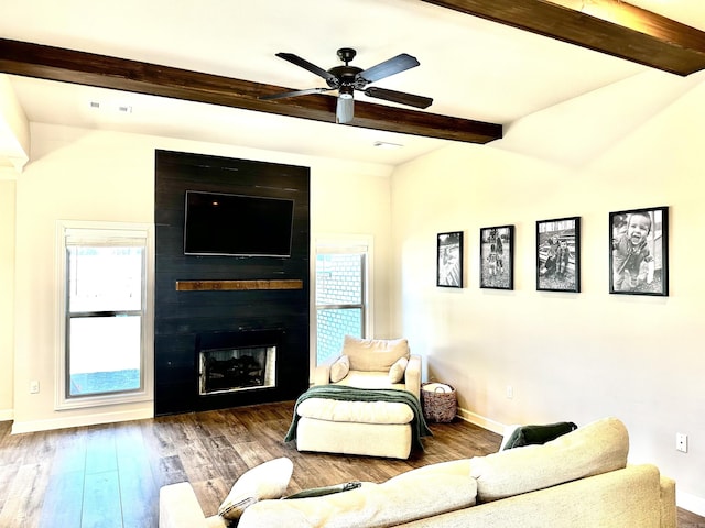 living room with a fireplace, hardwood / wood-style floors, ceiling fan, and beamed ceiling