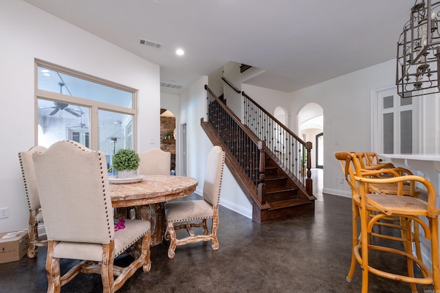 dining space featuring ceiling fan with notable chandelier