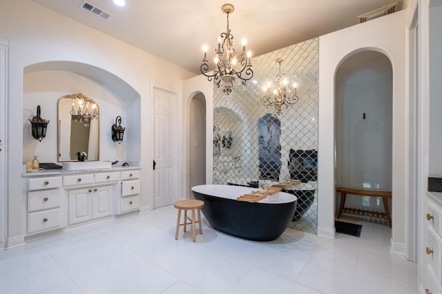 bathroom featuring vanity, a tub to relax in, and a chandelier