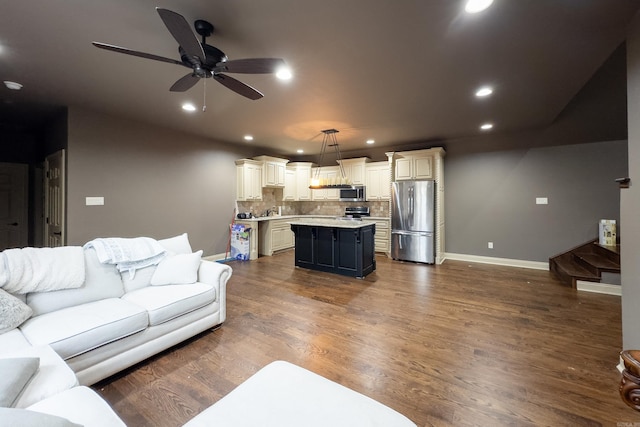 living room with ceiling fan and dark wood-type flooring