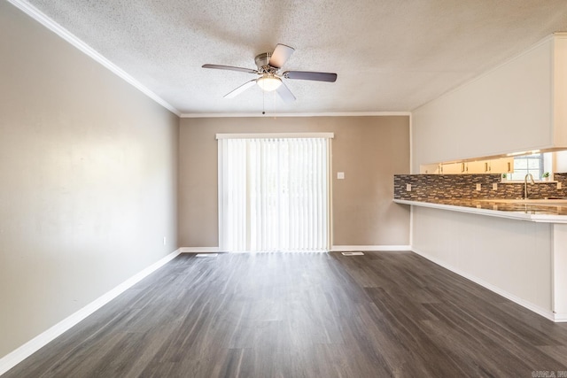 unfurnished living room featuring a textured ceiling, ceiling fan, crown molding, and dark hardwood / wood-style floors