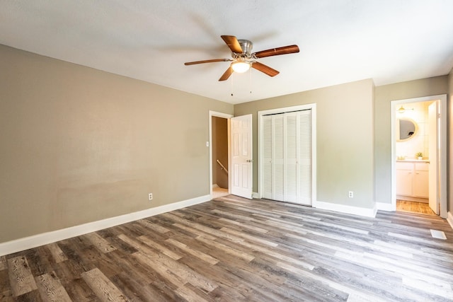 unfurnished bedroom with a closet, ceiling fan, hardwood / wood-style floors, and ensuite bathroom