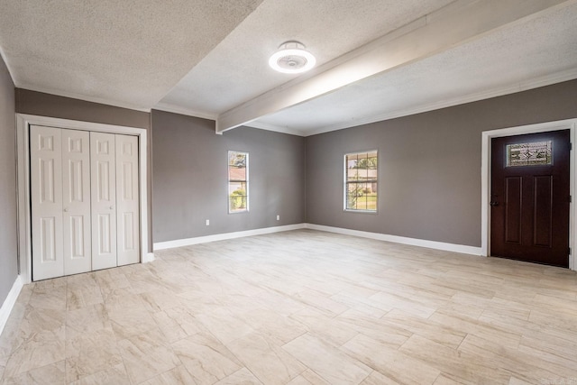 unfurnished bedroom with beam ceiling, a textured ceiling, a closet, and crown molding