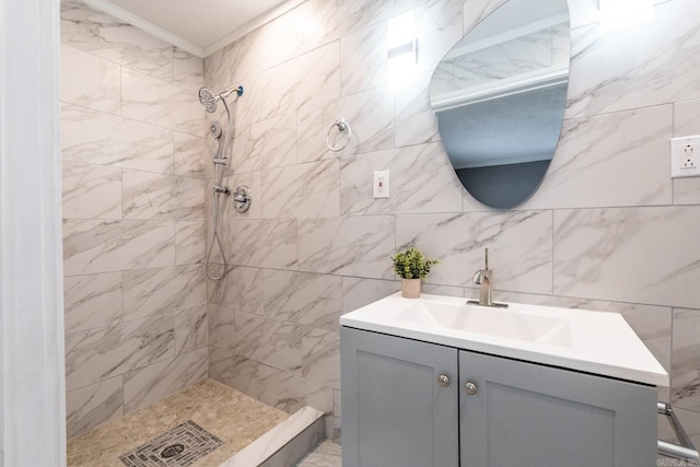 bathroom featuring vanity, tiled shower, crown molding, and tile walls