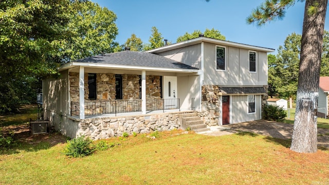 tri-level home featuring covered porch and a front lawn