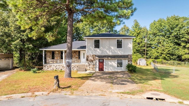 split level home featuring a porch, a shed, and a front yard