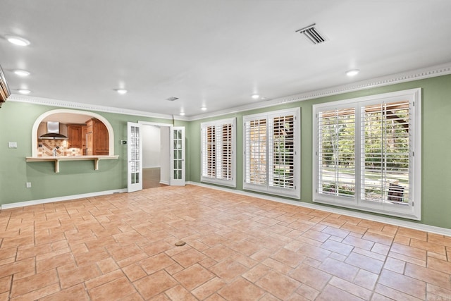 unfurnished living room with ornamental molding