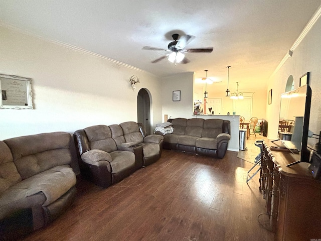 living room with ceiling fan with notable chandelier, dark hardwood / wood-style flooring, and ornamental molding