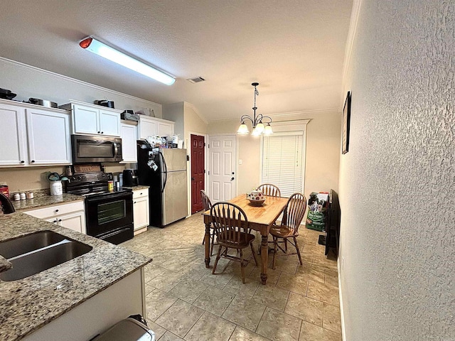 kitchen with sink, a textured ceiling, decorative light fixtures, white cabinets, and appliances with stainless steel finishes