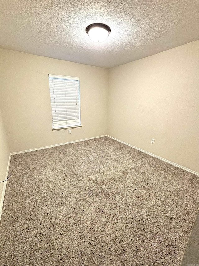 unfurnished room featuring carpet flooring and a textured ceiling