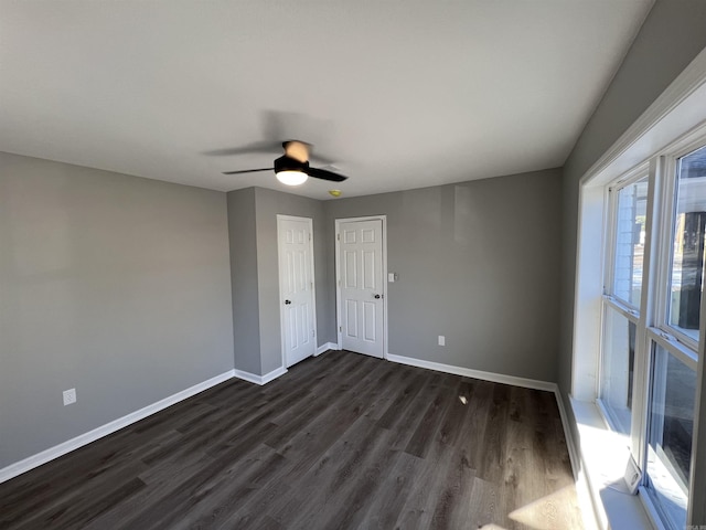 spare room with ceiling fan and dark wood-type flooring