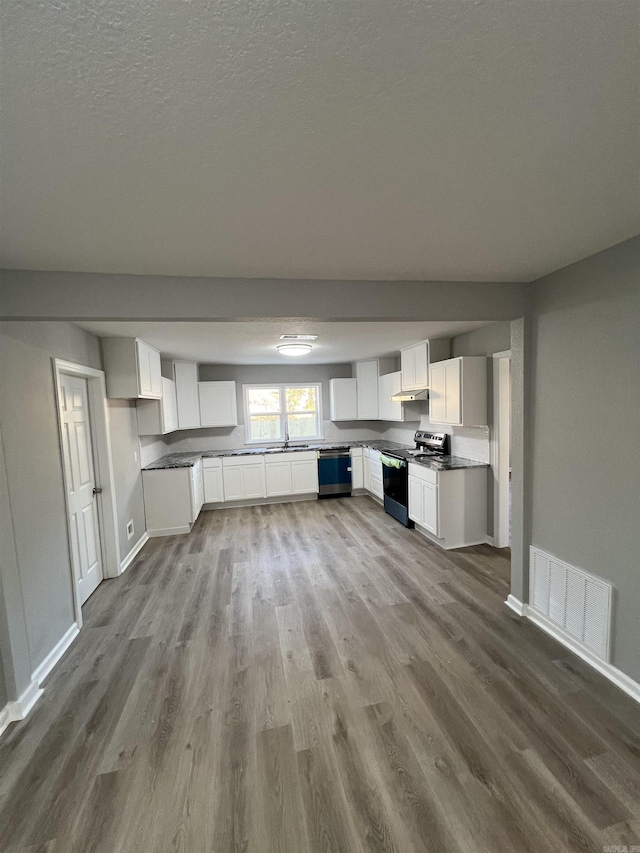 unfurnished living room featuring a textured ceiling and light wood-type flooring