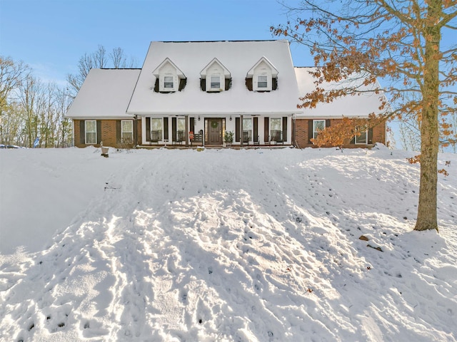 view of front facade featuring brick siding and a porch