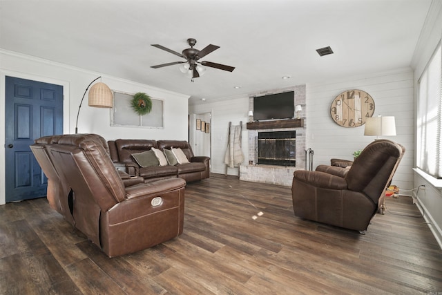 living room featuring a fireplace, dark hardwood / wood-style floors, ceiling fan, and ornamental molding