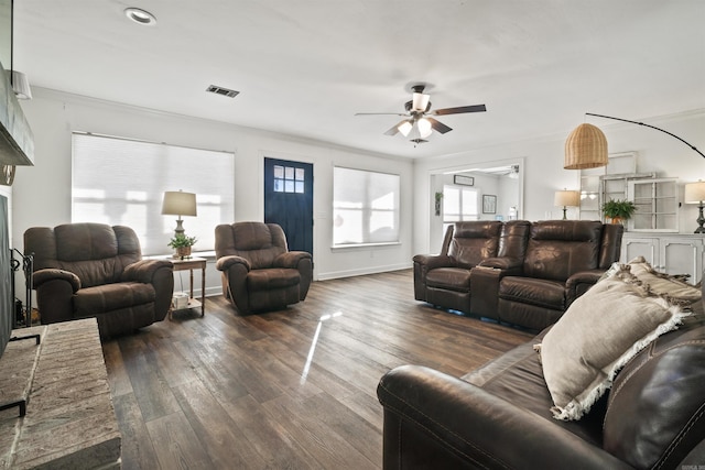 living room with baseboards, visible vents, dark wood-style flooring, ornamental molding, and ceiling fan