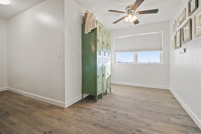 empty room with baseboards, wood finished floors, and a ceiling fan