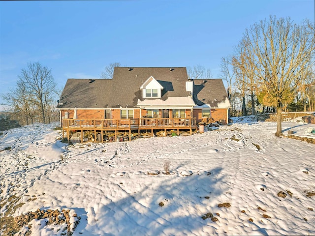 snow covered house featuring a deck