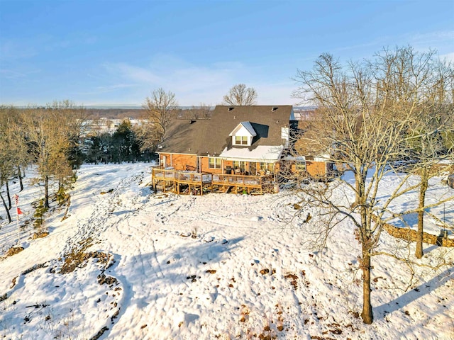 snow covered property featuring a wooden deck and stucco siding