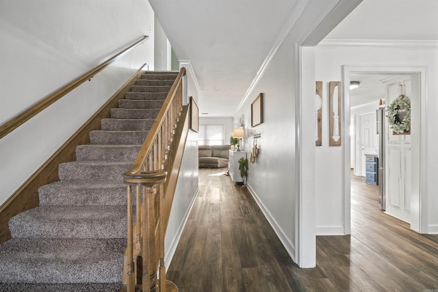 stairway featuring crown molding, baseboards, and wood finished floors