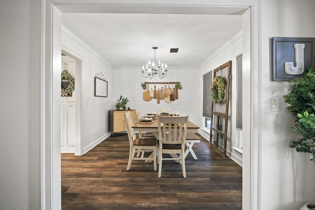 dining room with crown molding, dark hardwood / wood-style flooring, and a notable chandelier