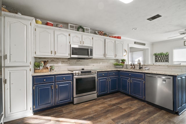 kitchen with white cabinets, dark hardwood / wood-style floors, blue cabinets, and stainless steel appliances