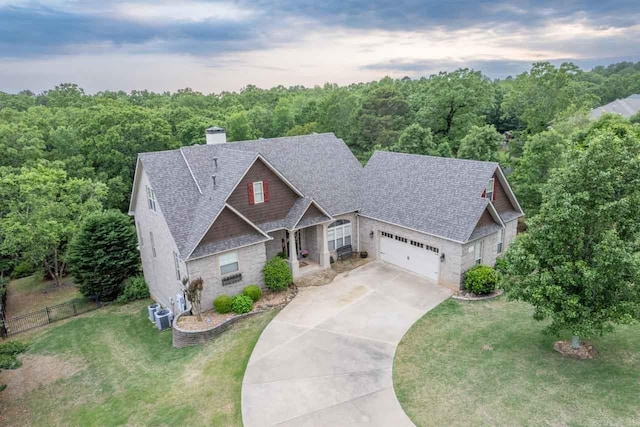 view of front of house with central AC unit, a garage, and a front yard