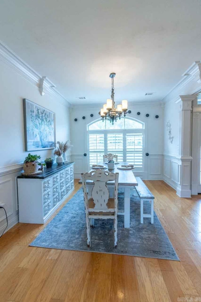 unfurnished dining area featuring crown molding, light hardwood / wood-style flooring, and a notable chandelier