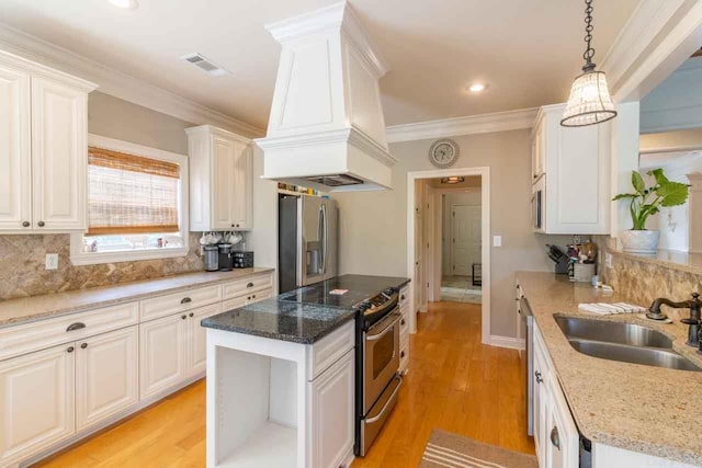 kitchen featuring white cabinets, a center island, sink, and appliances with stainless steel finishes