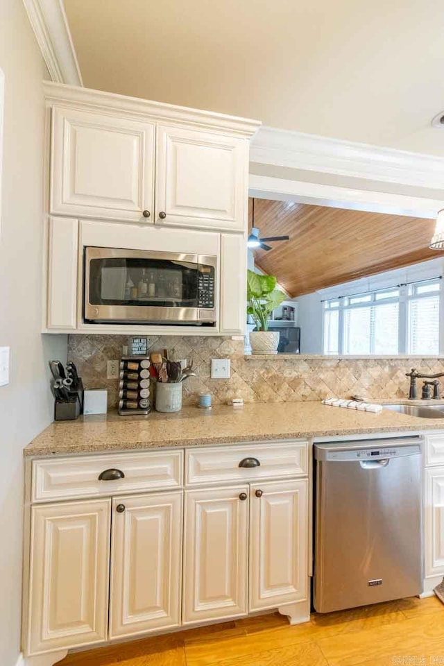 kitchen with appliances with stainless steel finishes, backsplash, white cabinetry, and ceiling fan