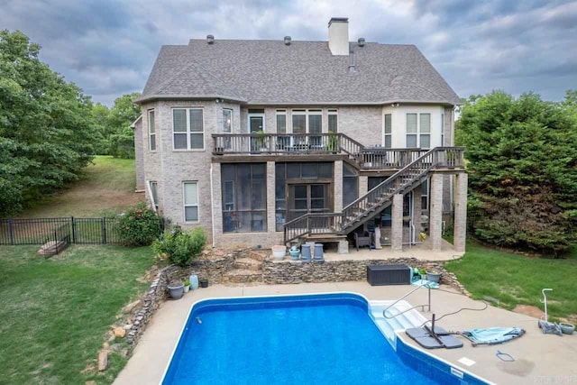 back of house featuring a fenced in pool, a sunroom, a yard, and a patio