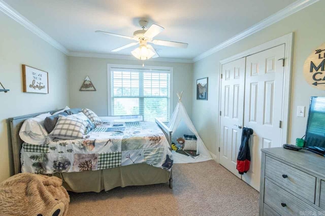 carpeted bedroom with ceiling fan, a closet, and ornamental molding