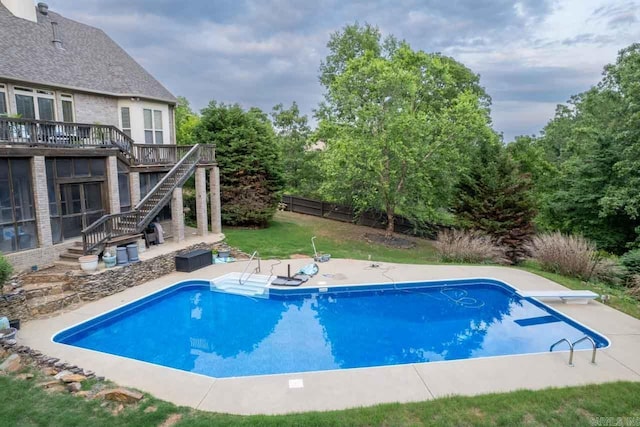 view of swimming pool featuring a diving board and a patio area